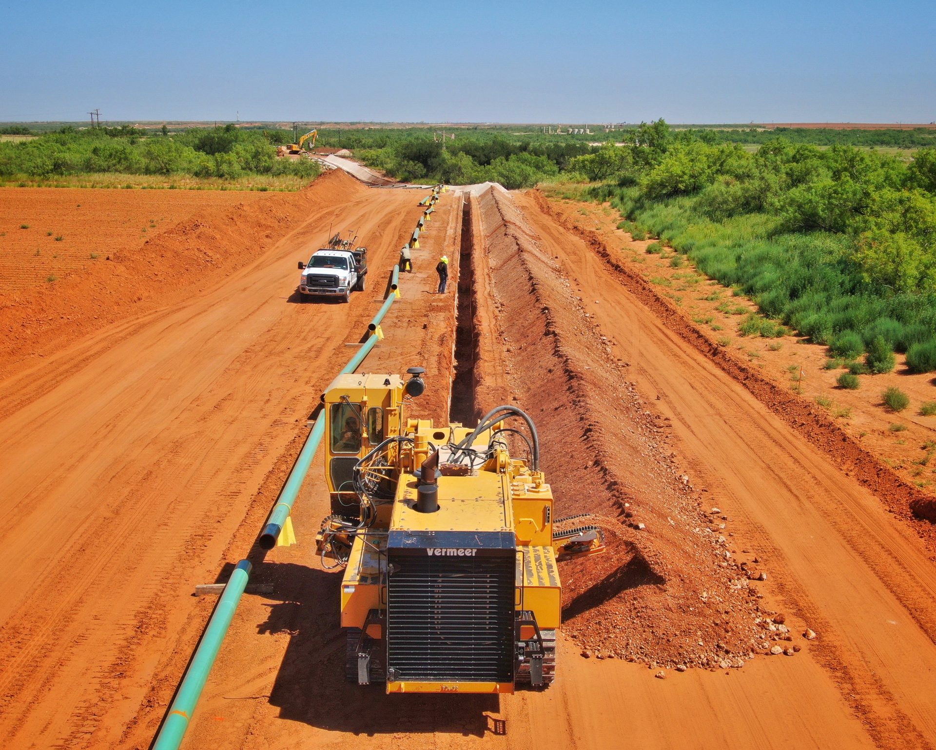 Aerial view of a gathering line trenching operation across a Permian Basin field
